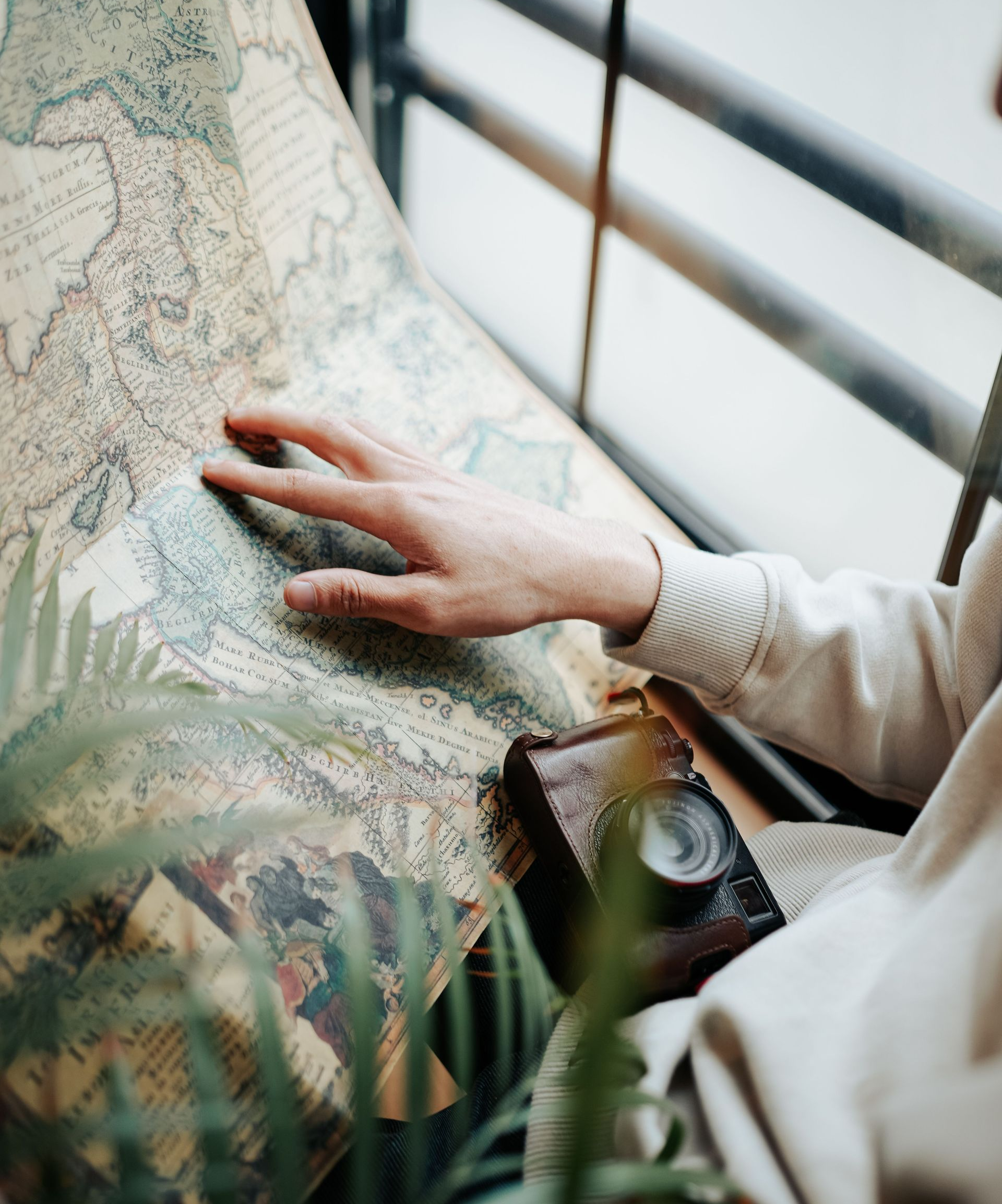 a colorful map with a woman's hand pointing at it