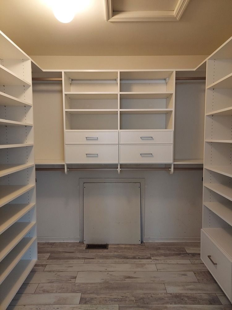 A walk in closet with lots of shelves and drawers.
