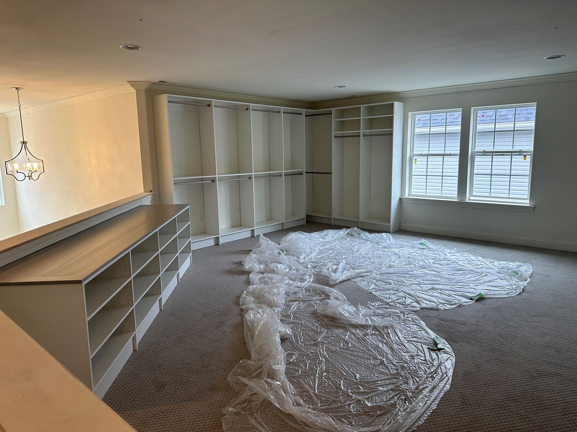 A large empty room with a lot of shelves and windows.