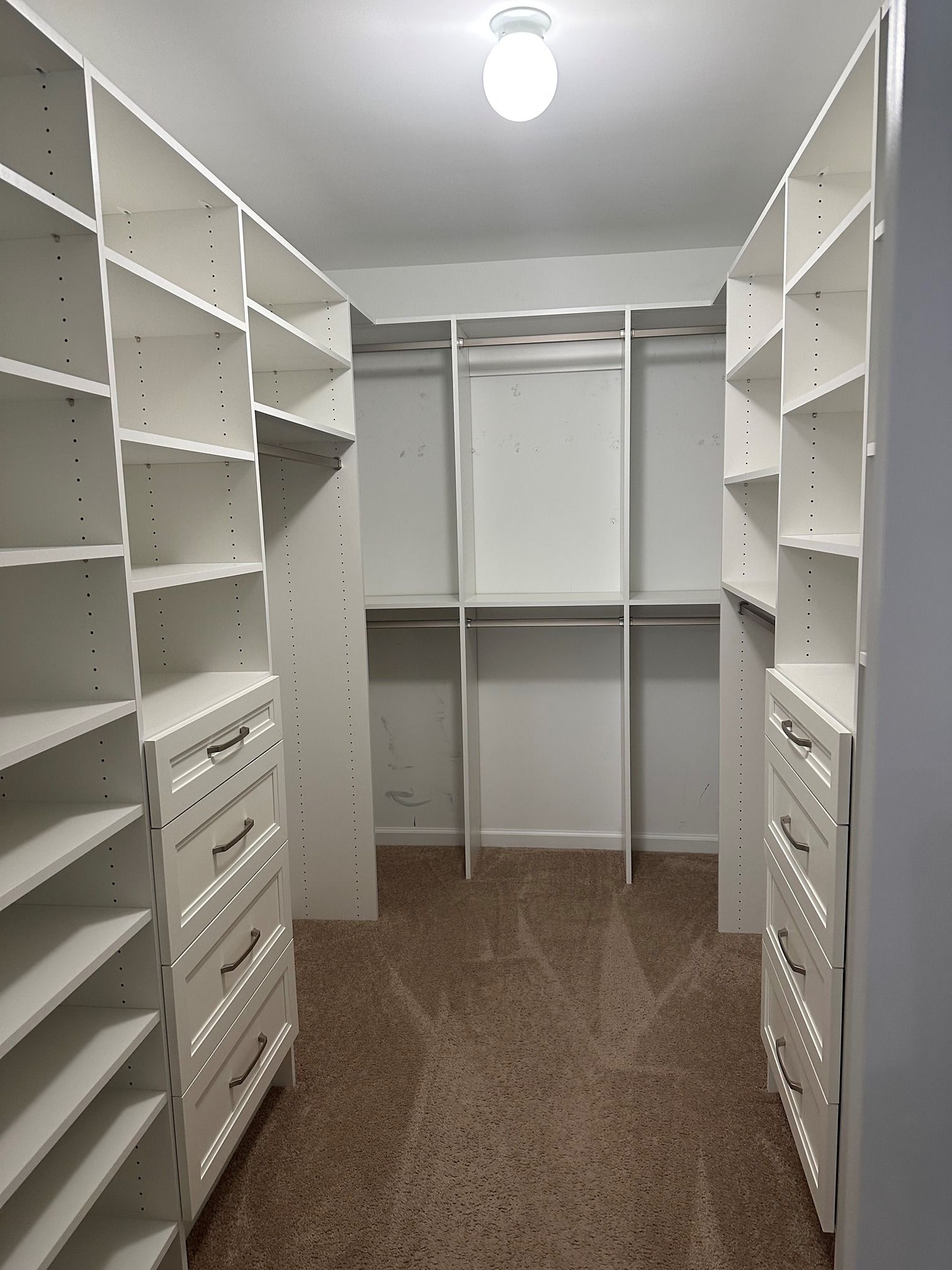 A walk in closet with lots of shelves and drawers.