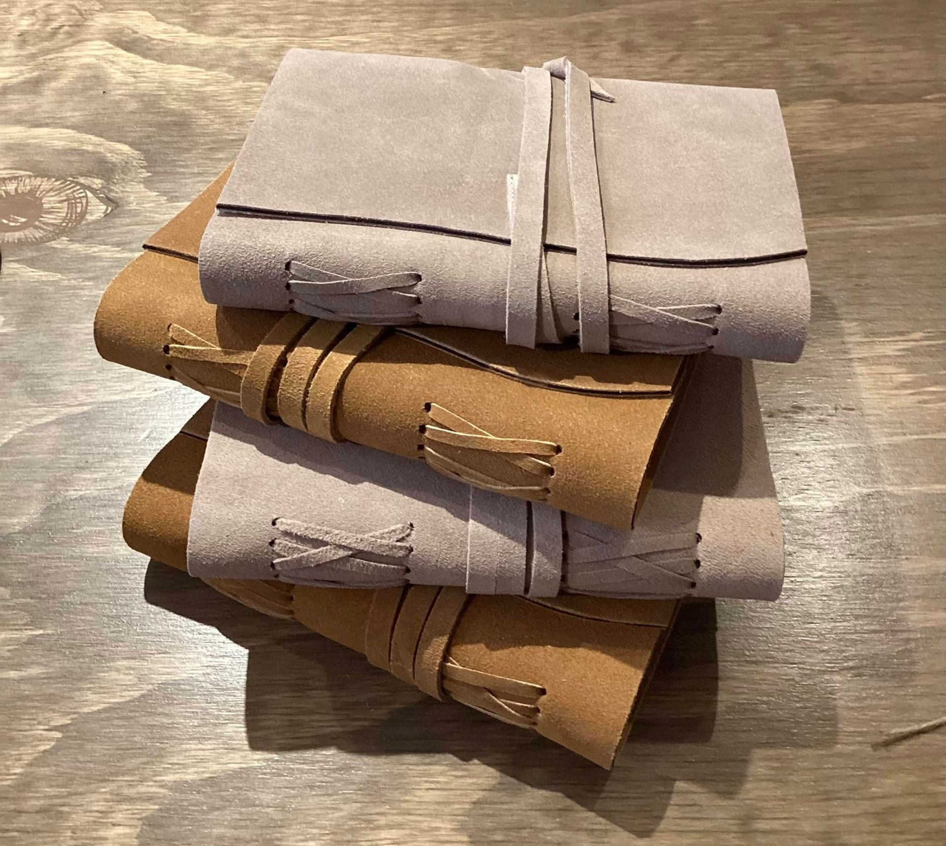 Stack of folded beige and tan fabric pouches on a textured surface