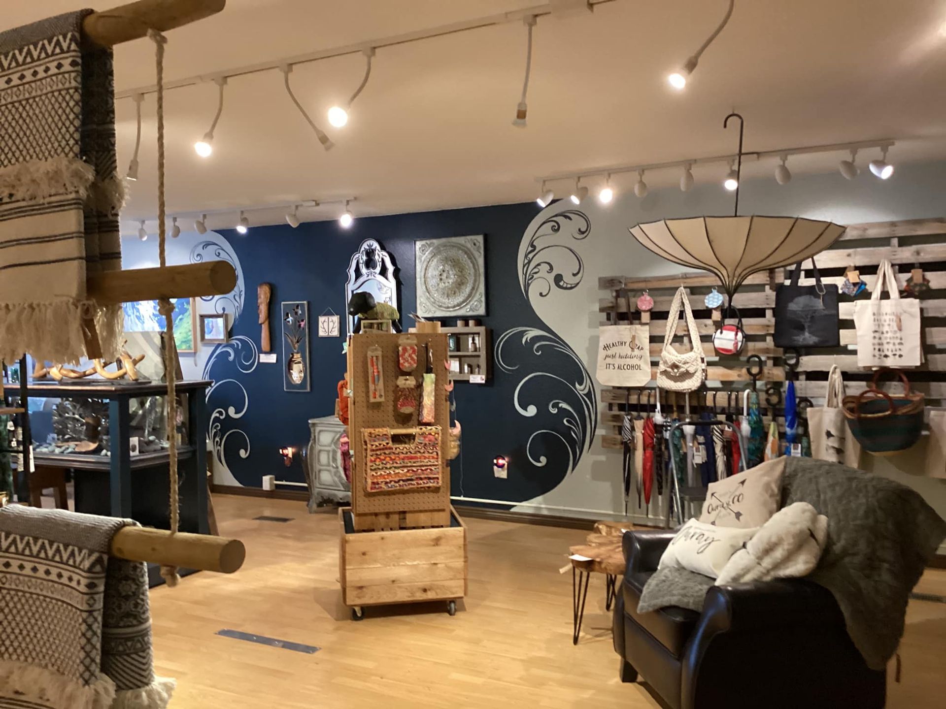 Cozy shop interior with string lights, wall art, shelves of home goods, and a seating area.