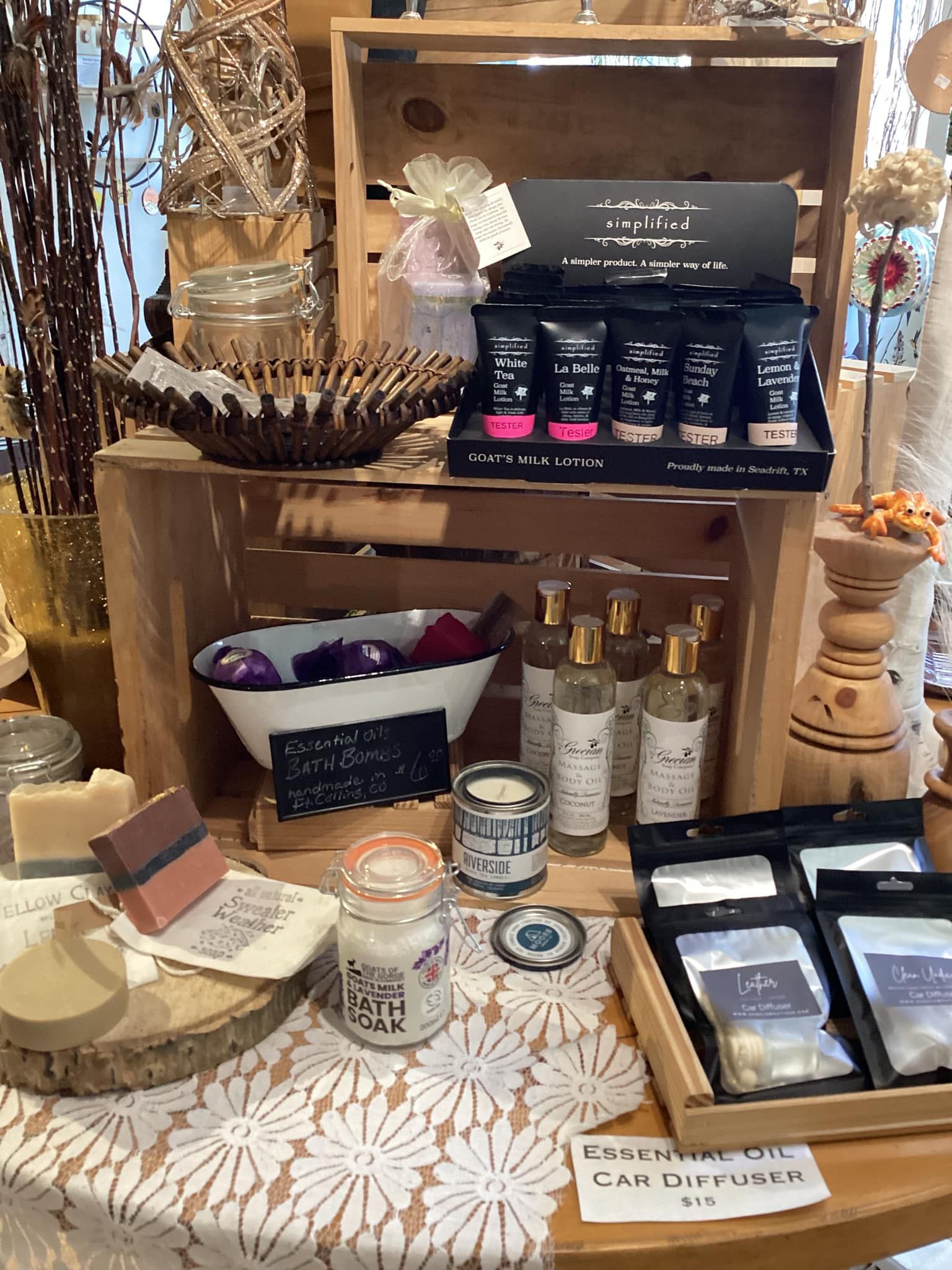 Display of assorted bath and beauty products on wooden crates and trays with decorative accents