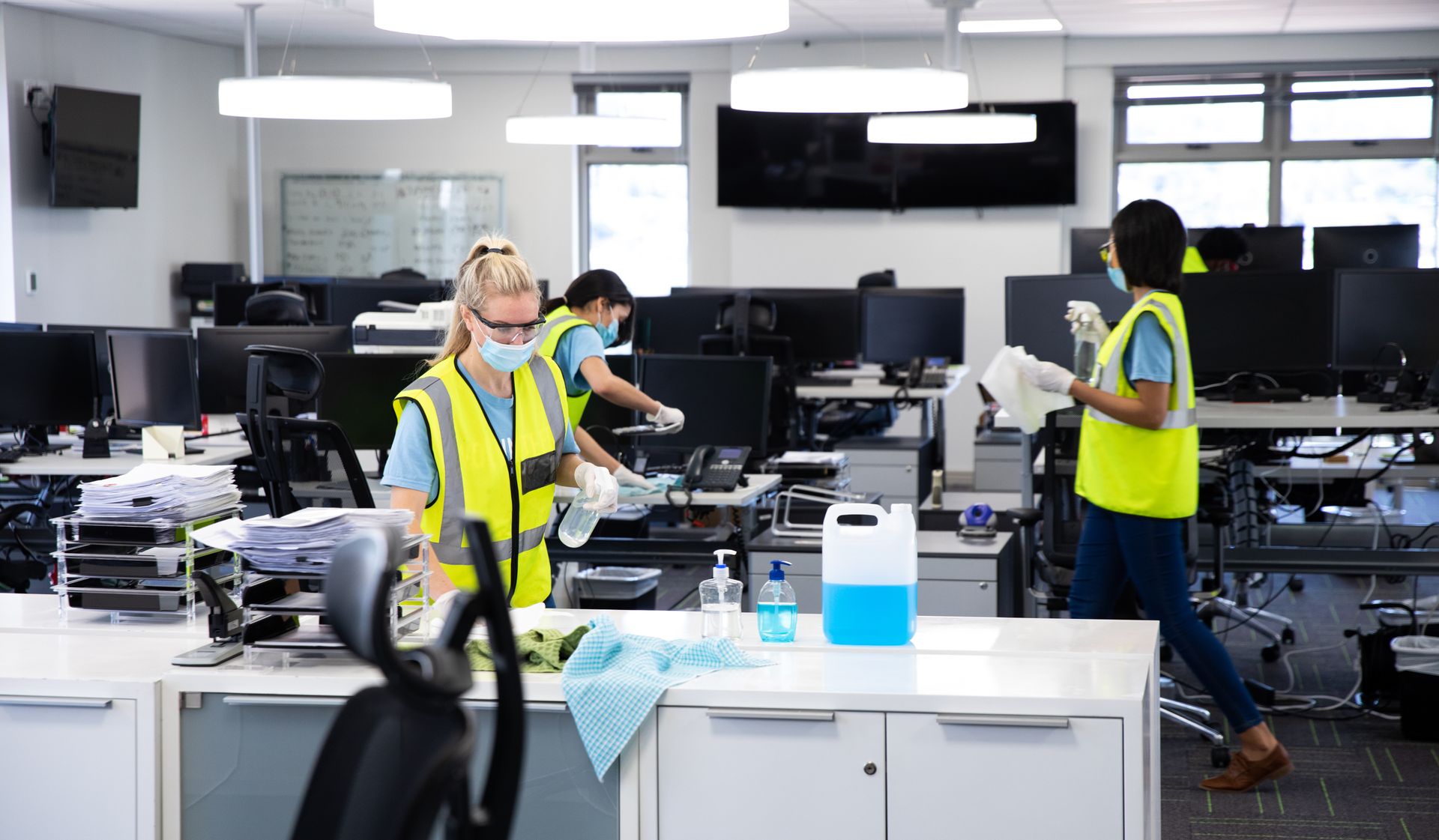 A group of people are cleaning a large office.
