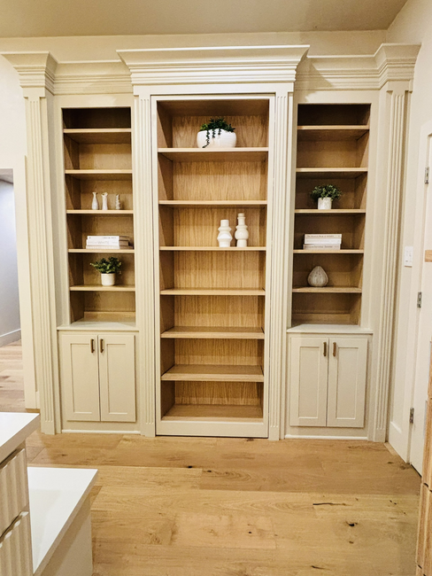 Craftsman inspecting a custom wood cabinet door with visible joinery detail in a cabinet workshop