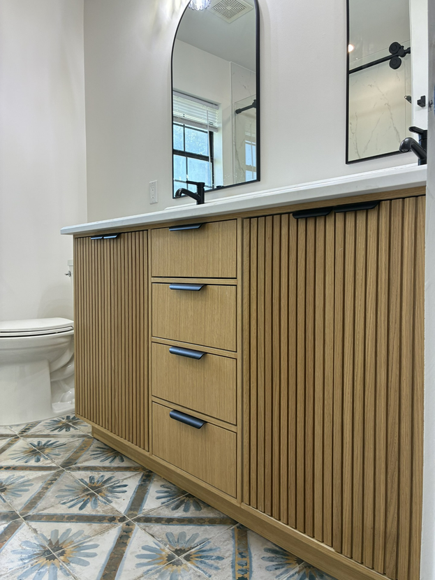Wide-angle view of a cabinet showroom floor with rows of custom cabinet displays in varied wood tones