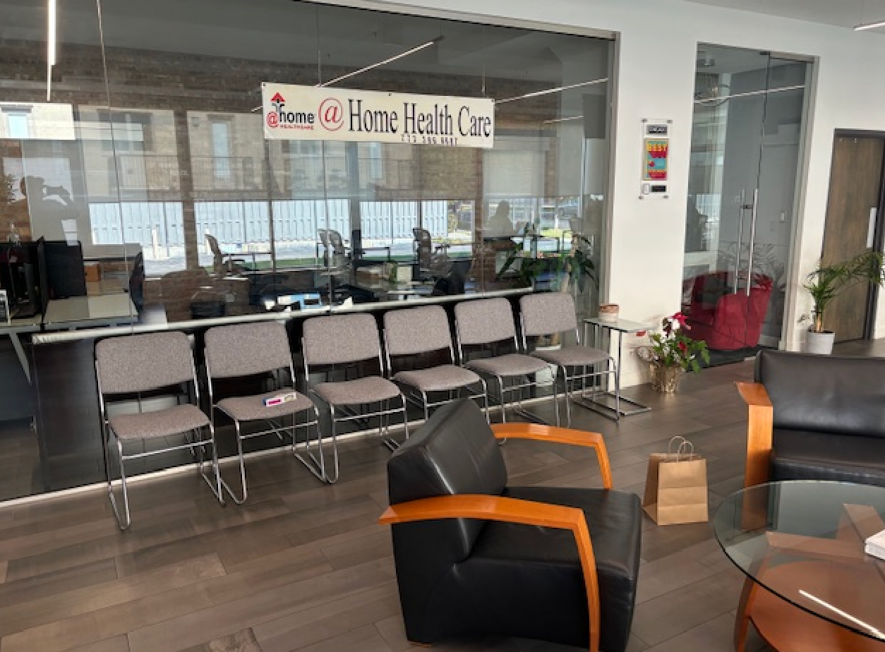 A waiting room with chairs , a couch , a table and a sign that says home health care.