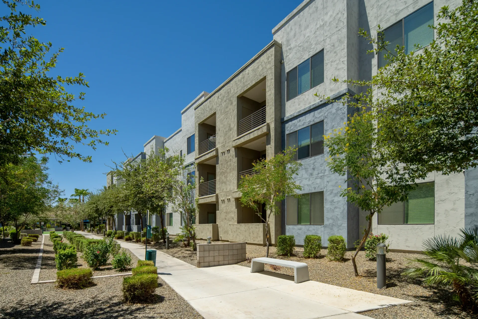 Modern apartment building exterior with balconies and landscaping at Parc South Mountain in Phoenix, AZ.
