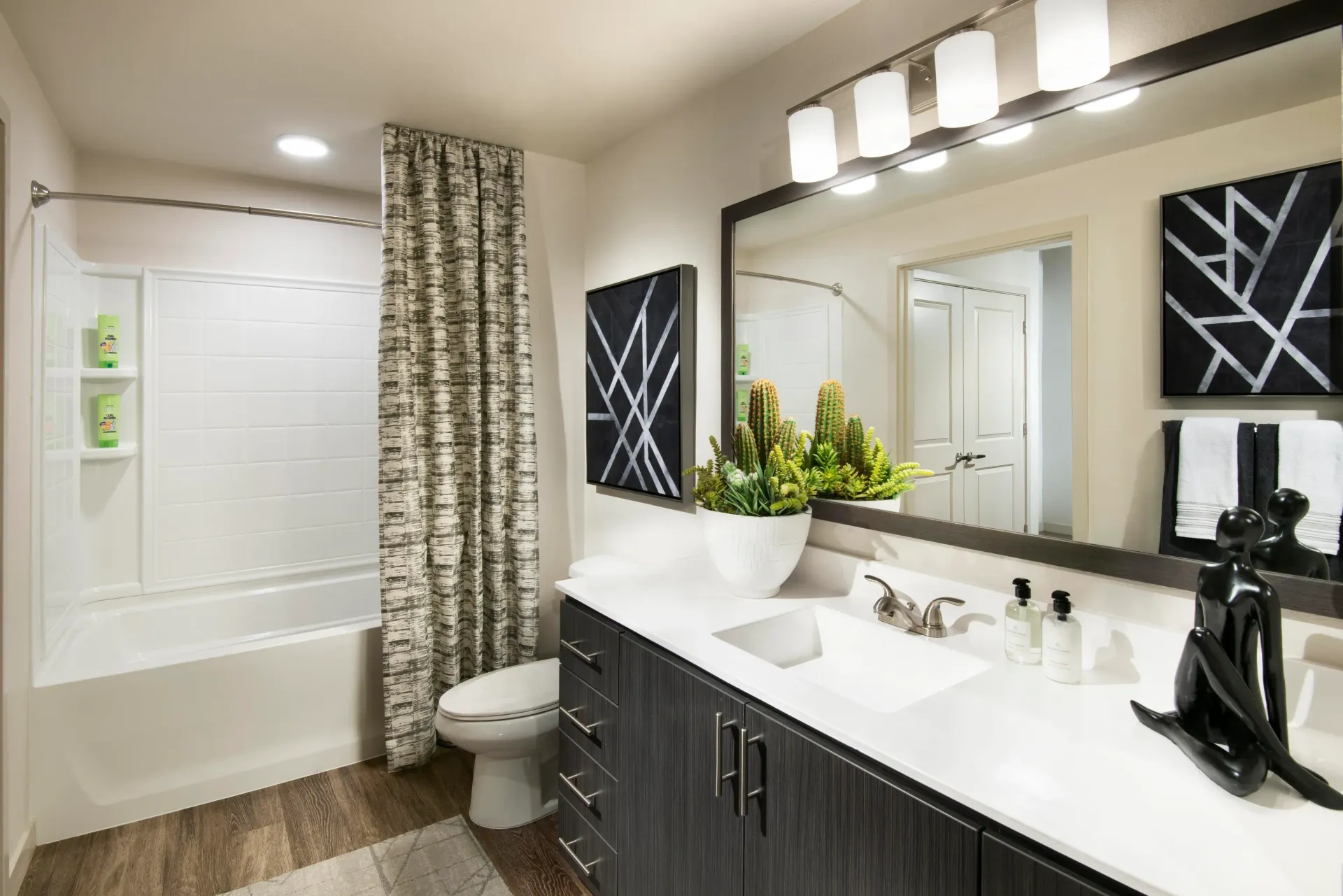 Modern bathroom with a bathtub, toilet, and double vanity at Parc South Mountain in Phoenix, AZ.