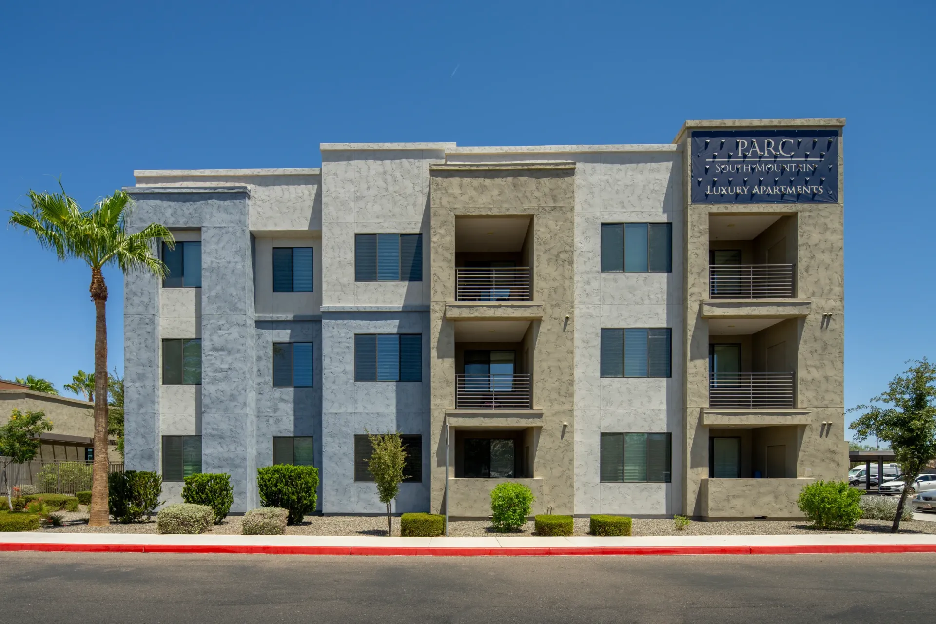 Parc South Mountain Luxury Apartments building exterior with a palm tree at Parc South Mountain in Phoenix, AZ.