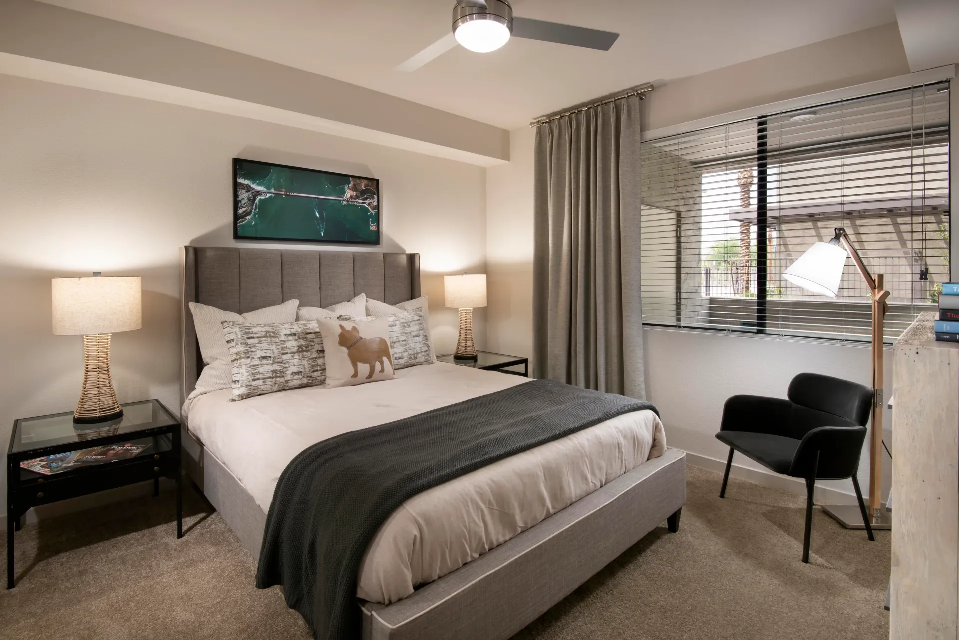 Bedroom with a king-size bed, bedside tables, a ceiling fan, and a large window with blinds at Parc South Mountain in Phoenix, AZ.