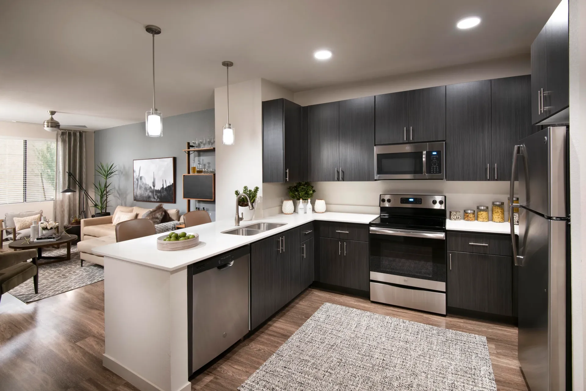 Modern kitchen with dark cabinets, stainless steel appliances, and a large island.