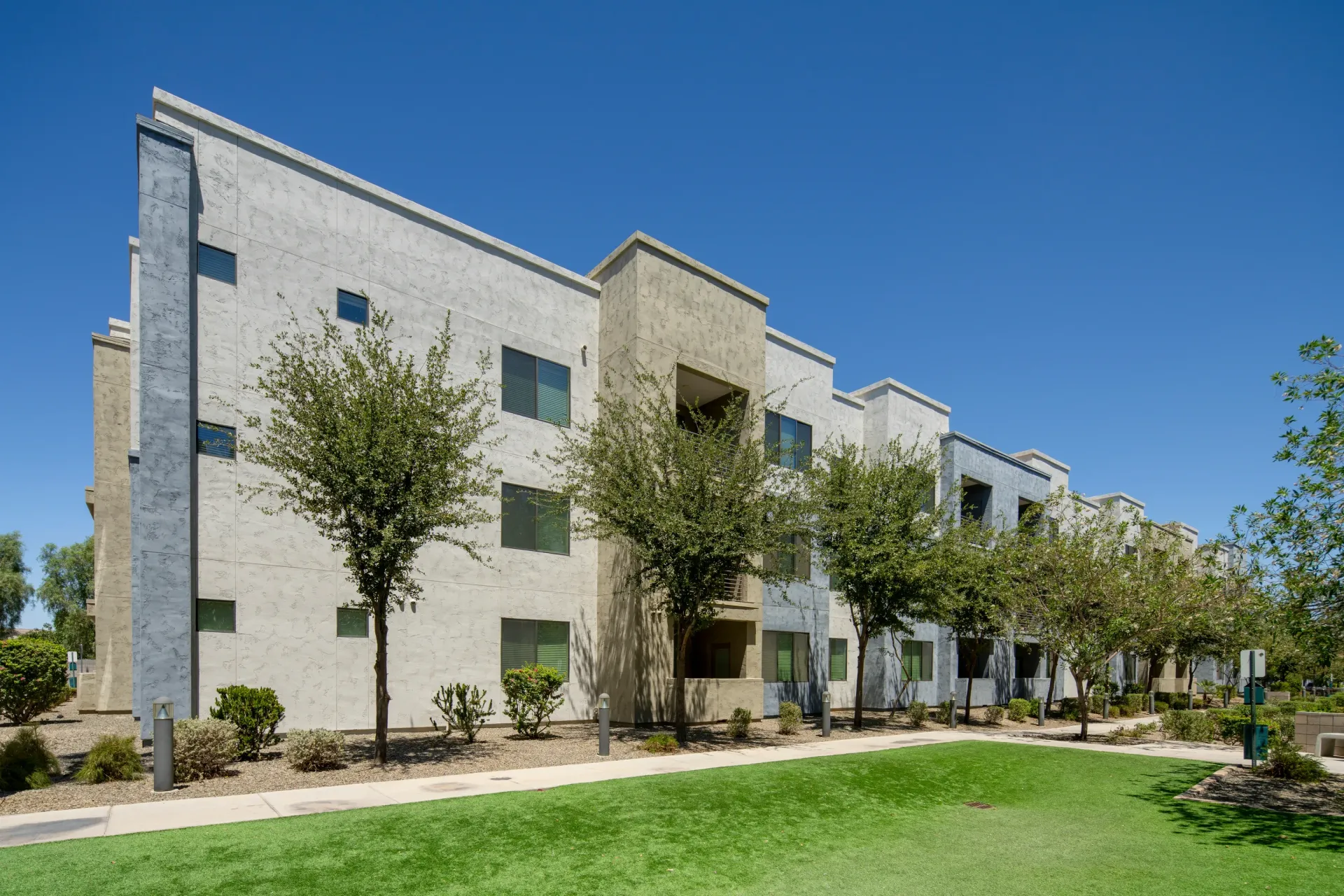 Exterior of apartment building with stucco facade and modern architecture at Parc South Mountain in Phoenix, AZ.