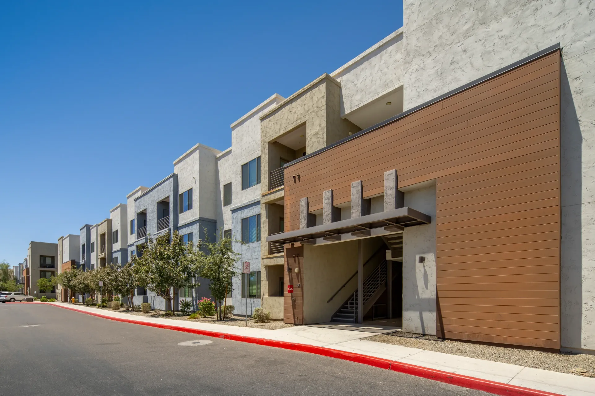 Exterior of modern apartment buildings with balconies and colorful facades at Parc South Mountain in Phoenix, AZ.