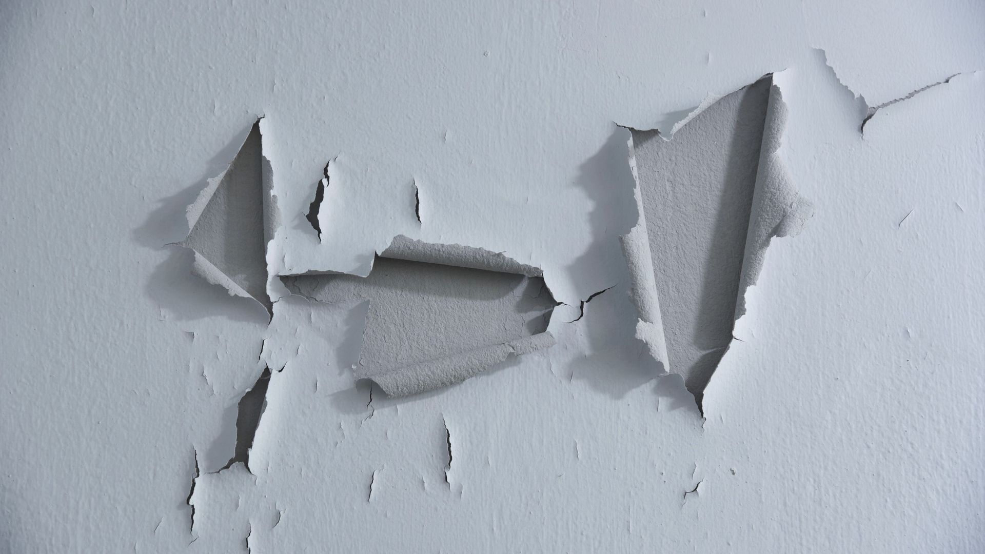 A close up of a white wall with a hole in it.