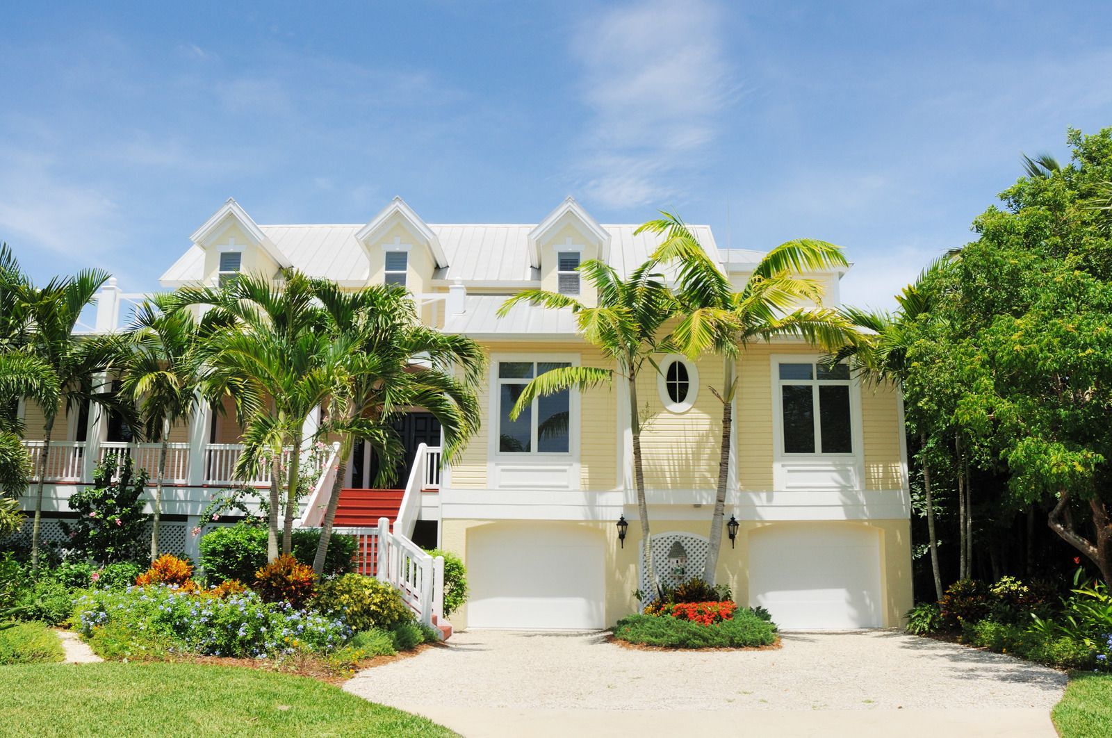 Blue-roofed house gables under a bright sunny sky with white clouds