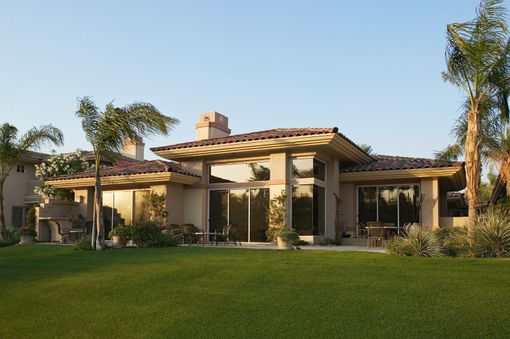 Dark gray shingled roof with steep gables and a small skylight against trees