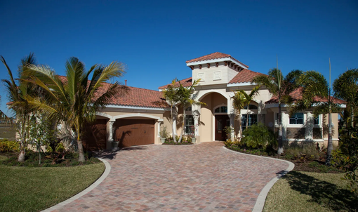 Dark gray shingled roof with steep gables and a small skylight against trees