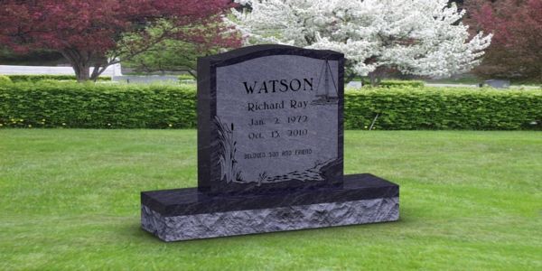A gravestone in a cemetery with a tree in the background.