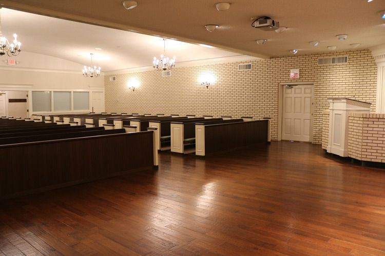 An empty church with wooden floors and a brick wall