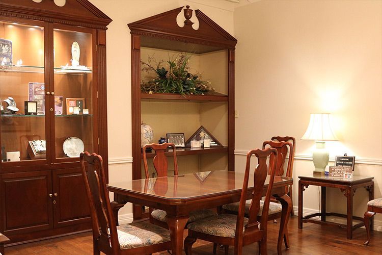 A dining room with a table and chairs and a hutch.
