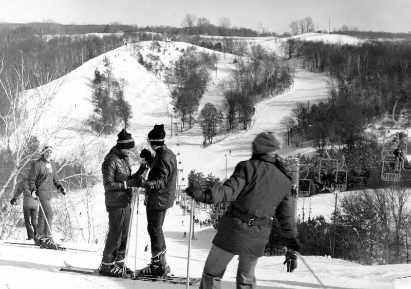A group of people standing on top of a snow covered hill