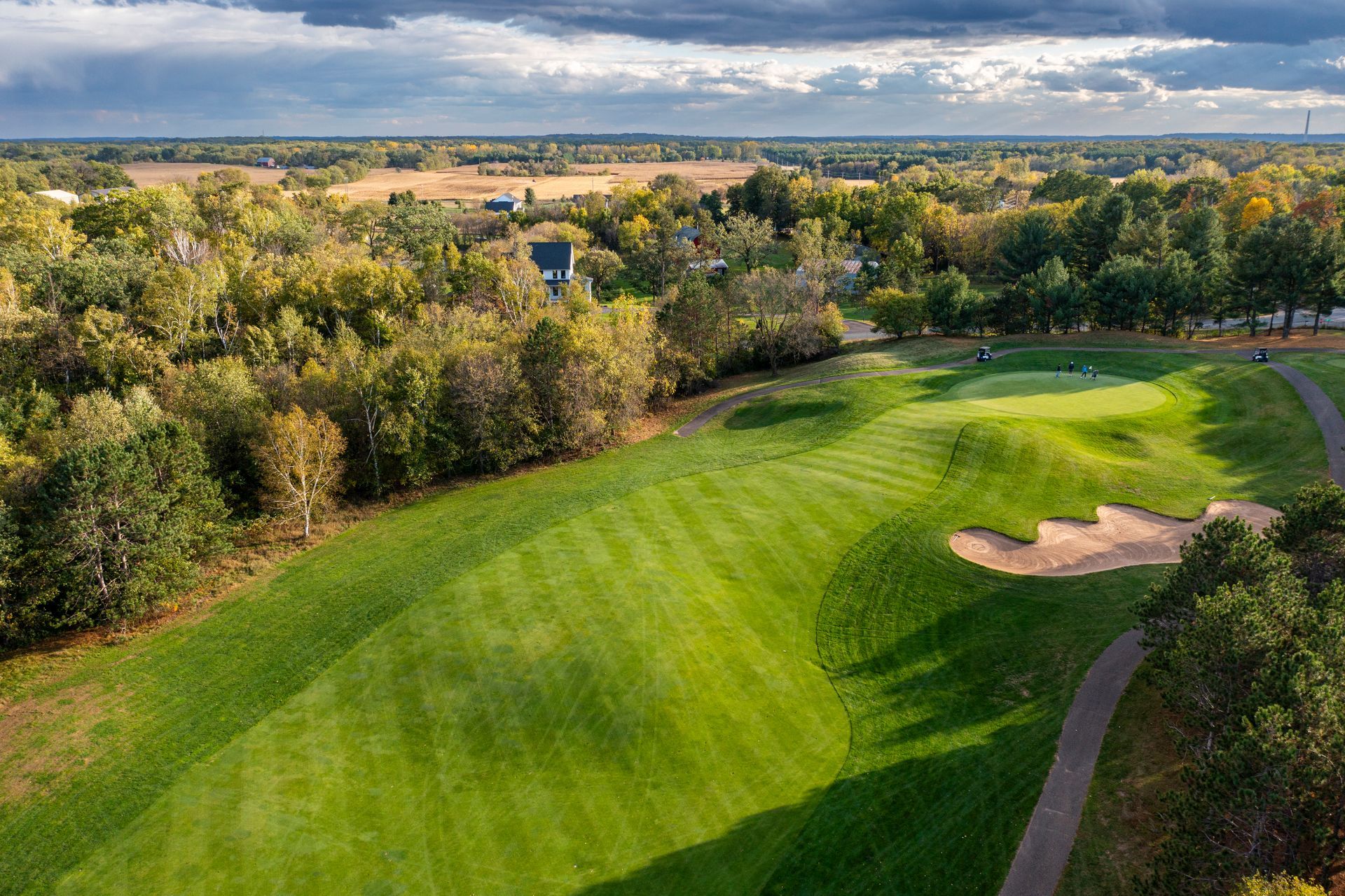 An aerial view of a golf course surrounded by trees.