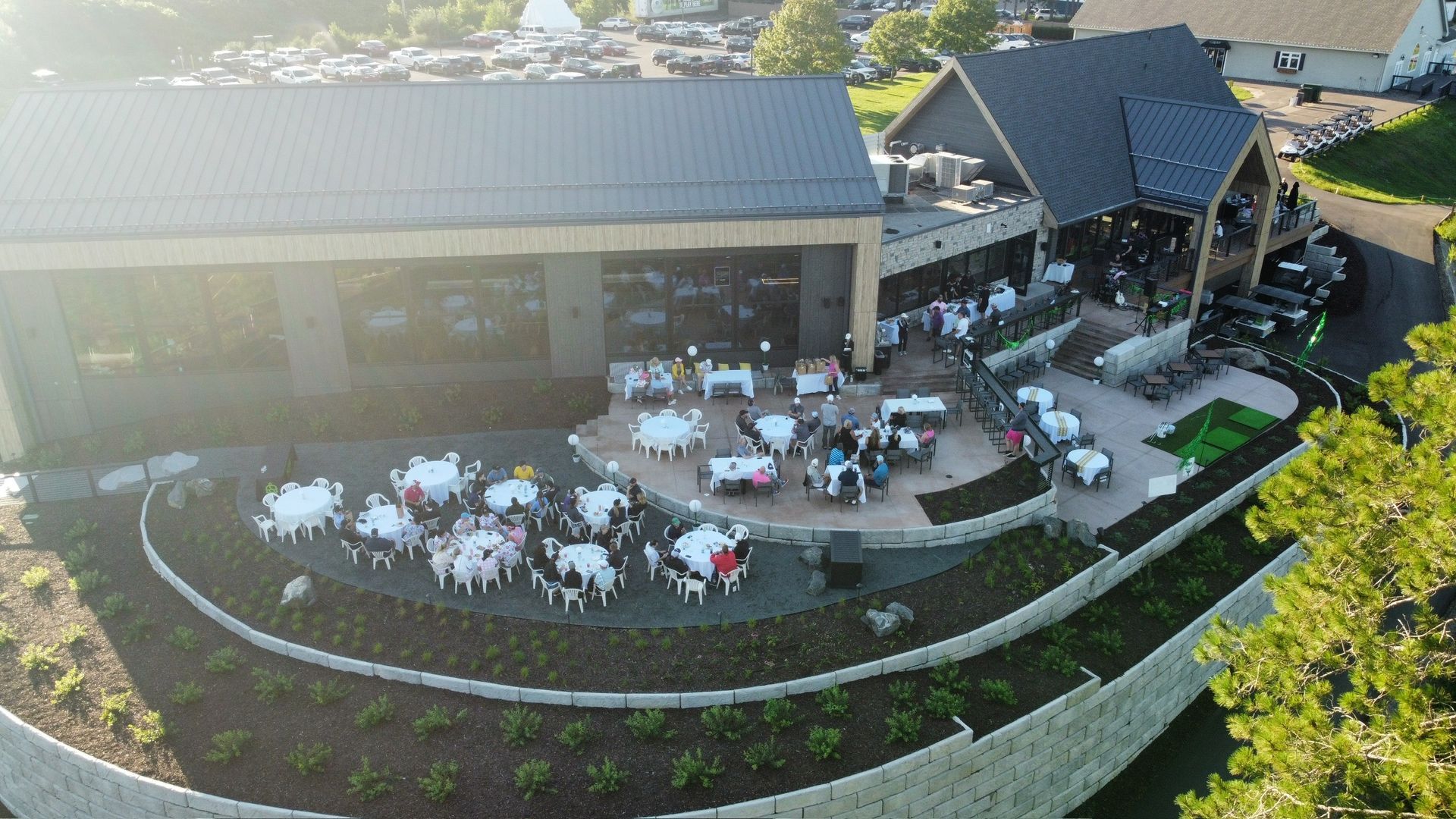 An aerial view of a large building with tables and chairs outside.