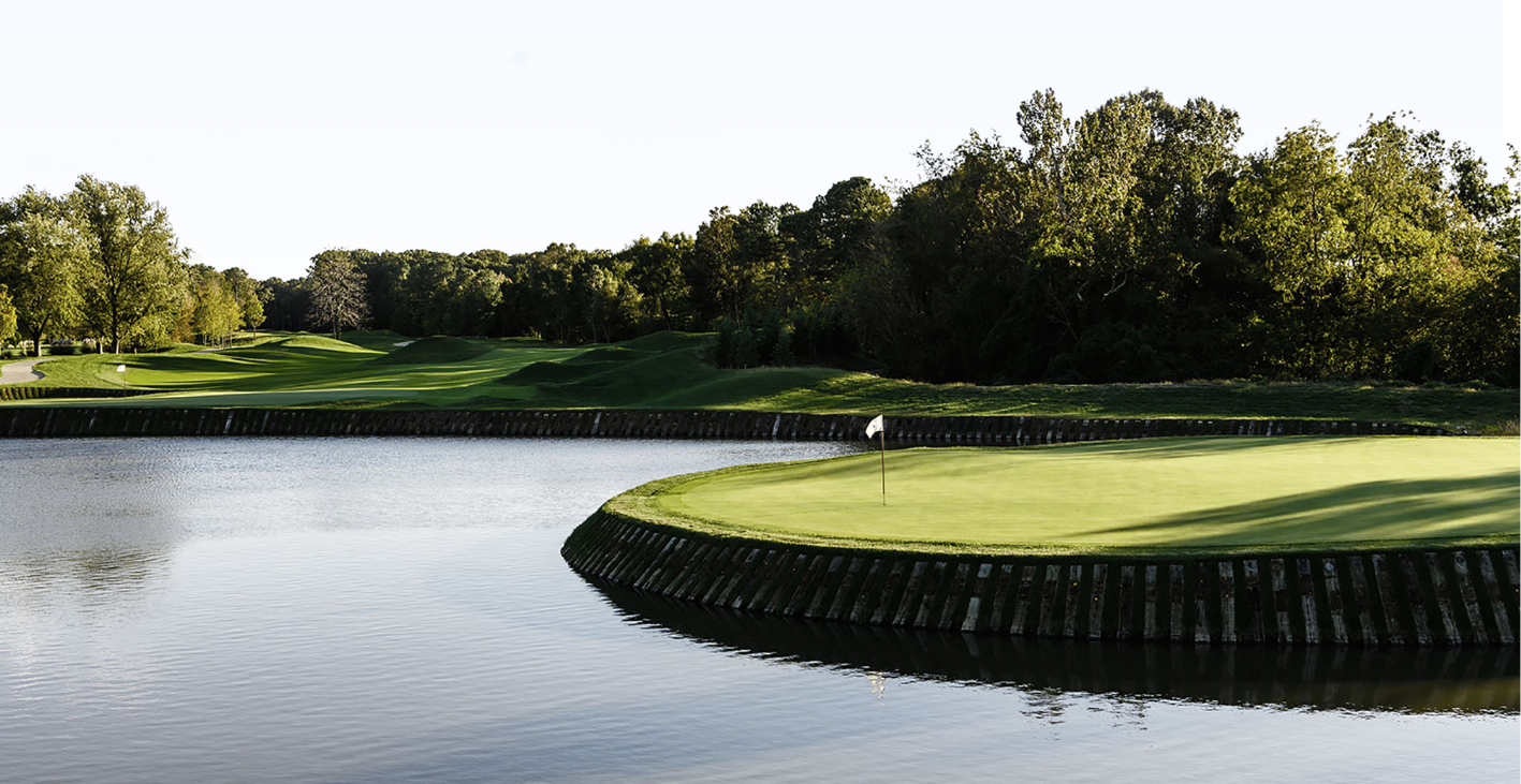 A golf course with a pond in the middle of it. Play world-famous courses year-round with HD Golf Simulators at SCN Golf