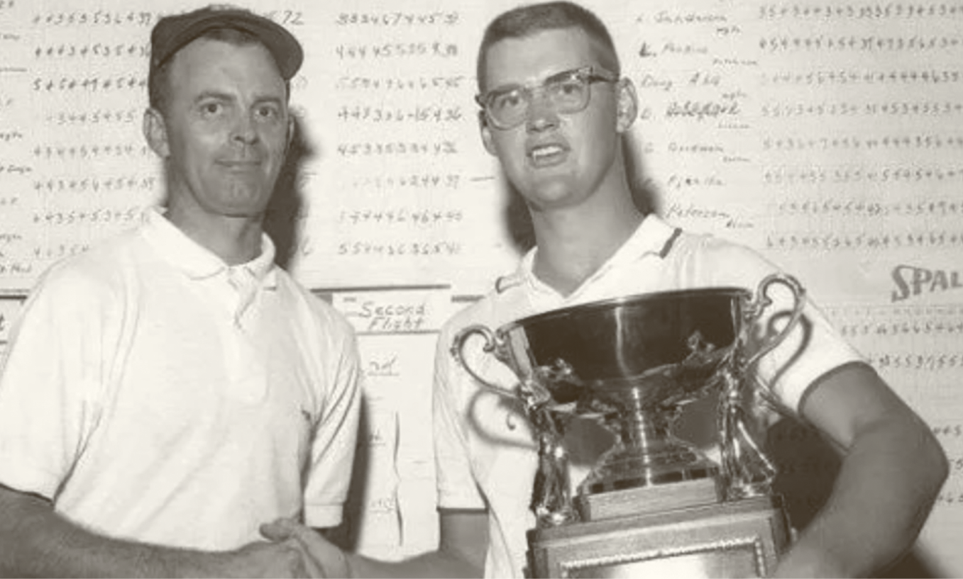 Two men are shaking hands and holding a trophy.