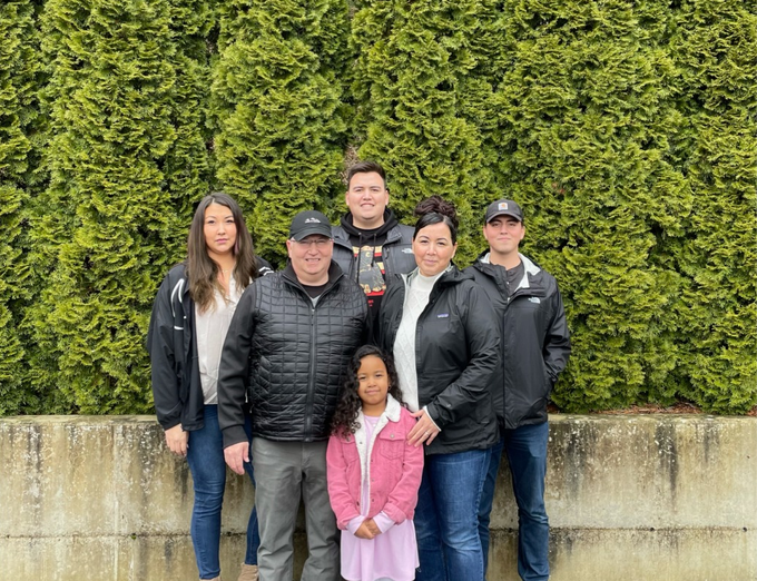 a family posing for a picture with trees in the background