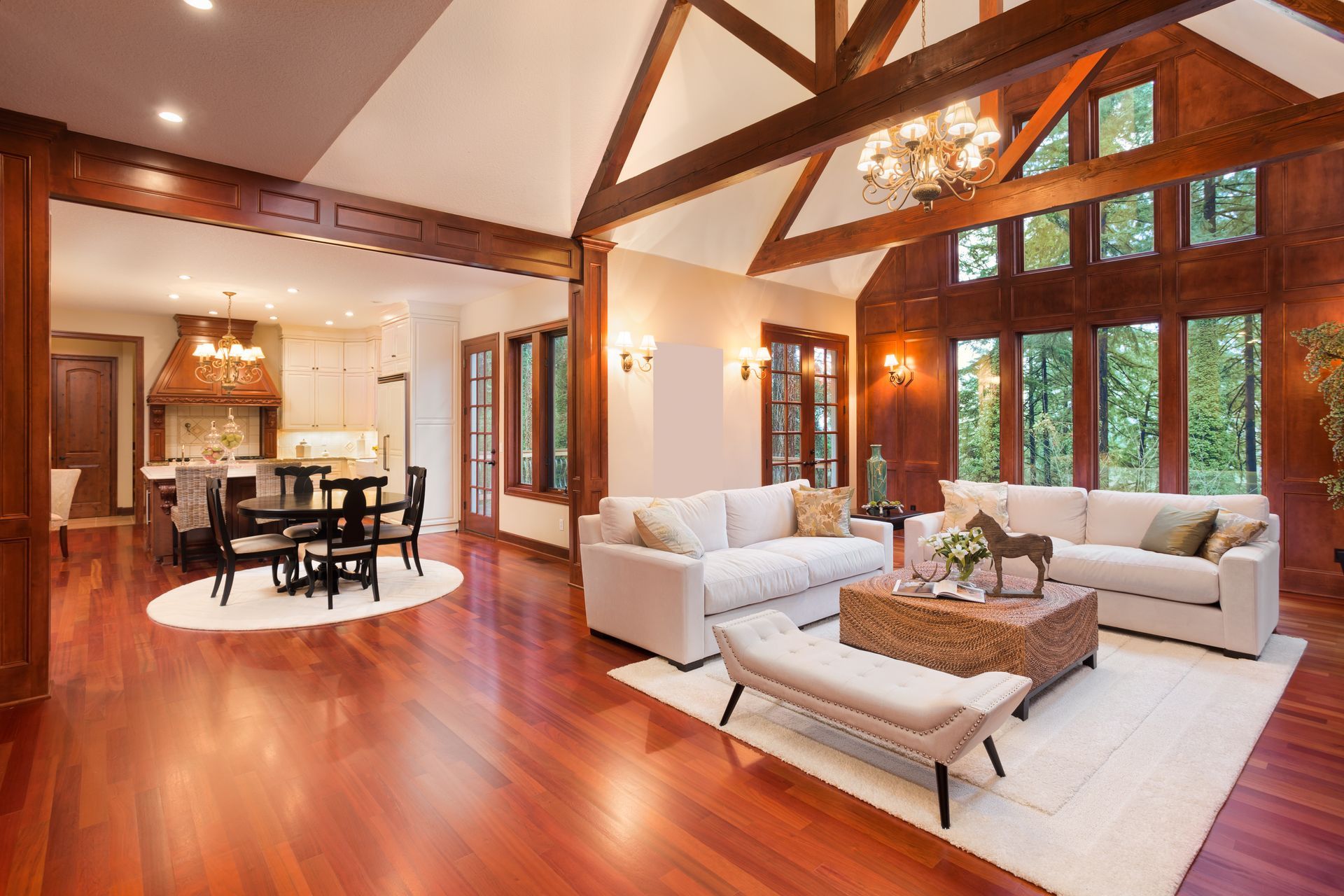 Spacious living room and kitchen with wood floors and vaulted ceilings.