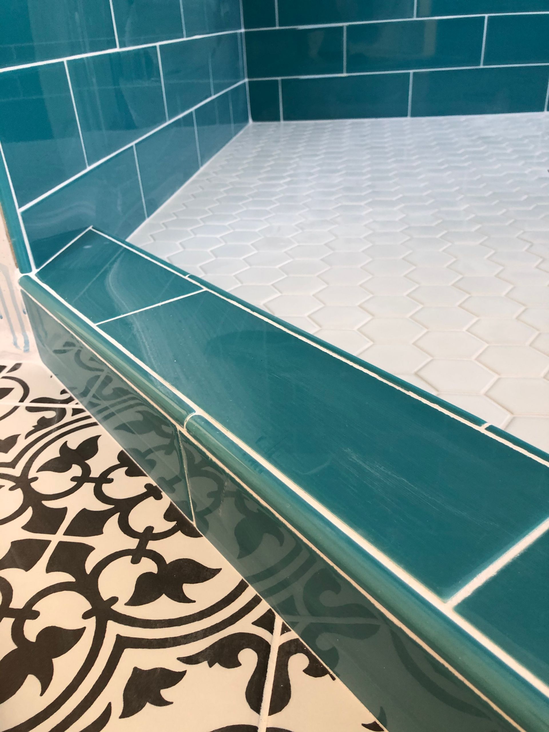 A bathroom with blue tiles and a black and white floor