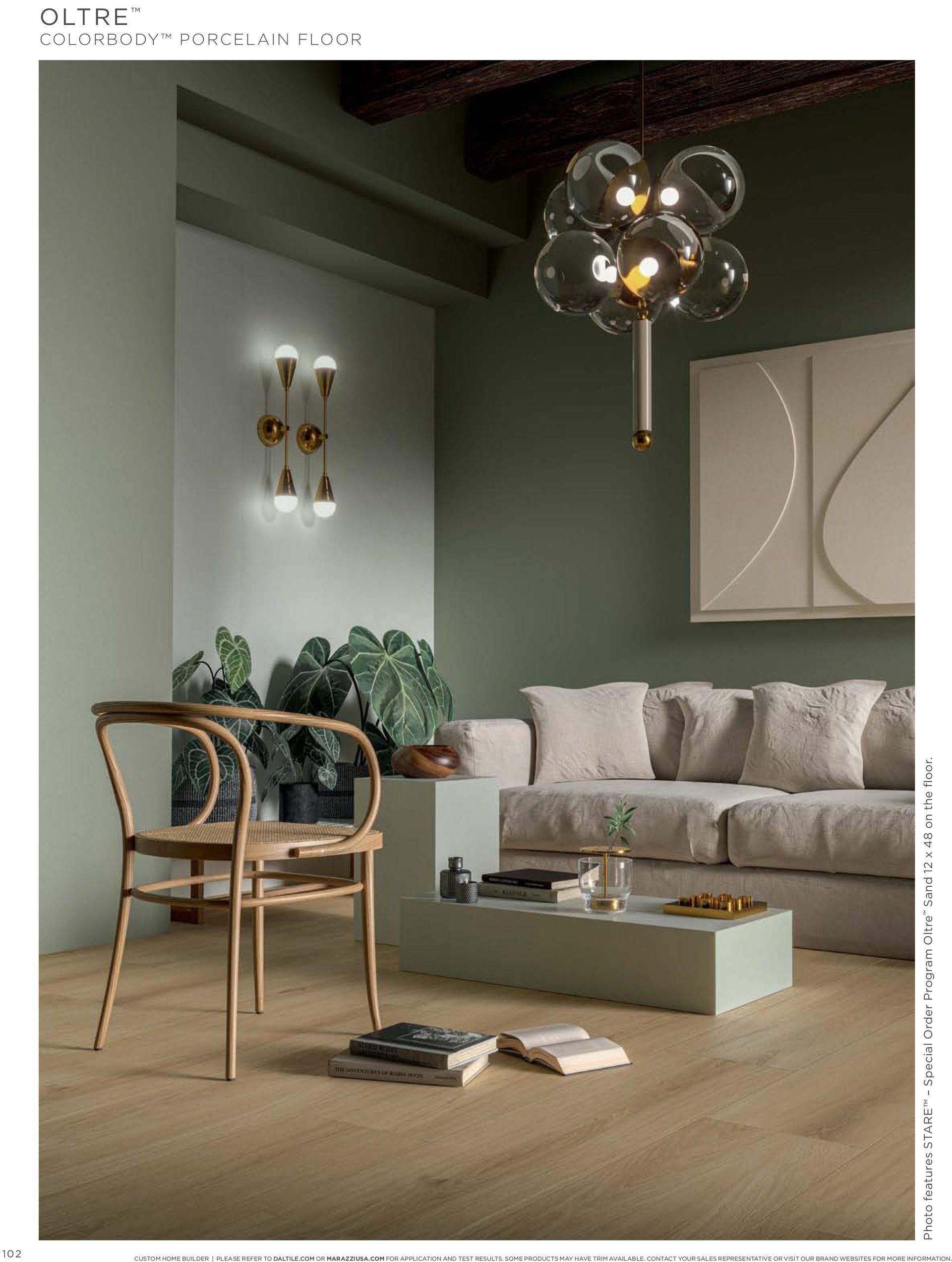 A living room with a couch , chair , table and chandelier.