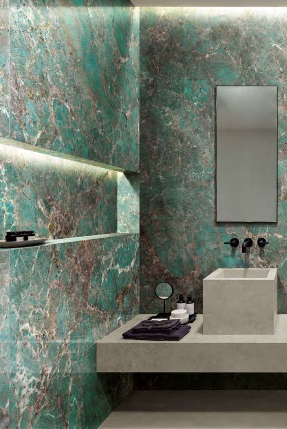 Large format tile | A bathroom with a sink , mirror and green tiles.