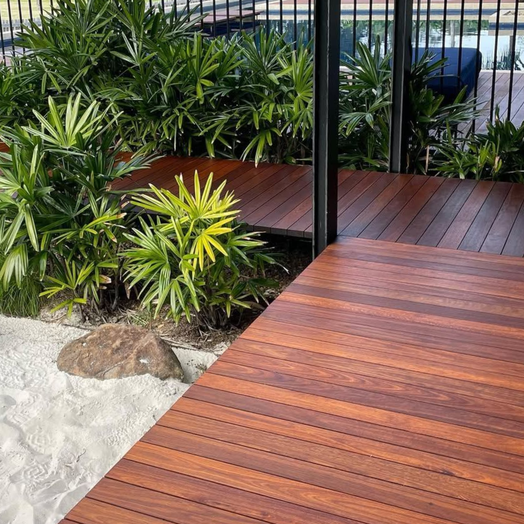 Person Staining a Wooden Deck; the Stained Portion is Dark, the Rest is Light — CM Timber Flooring in East Ballina, NSW