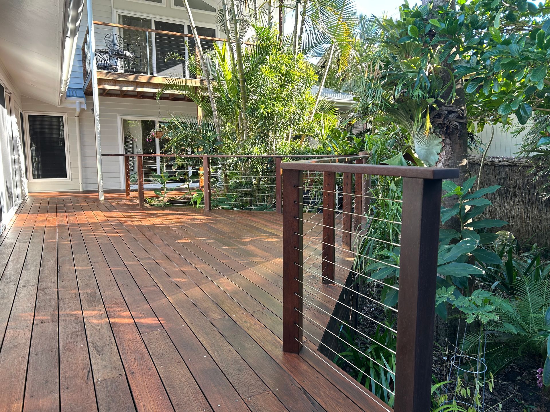 Wooden deck with cable railing overlooking a lush garden — CM Timber Flooring in East Ballina, NSW