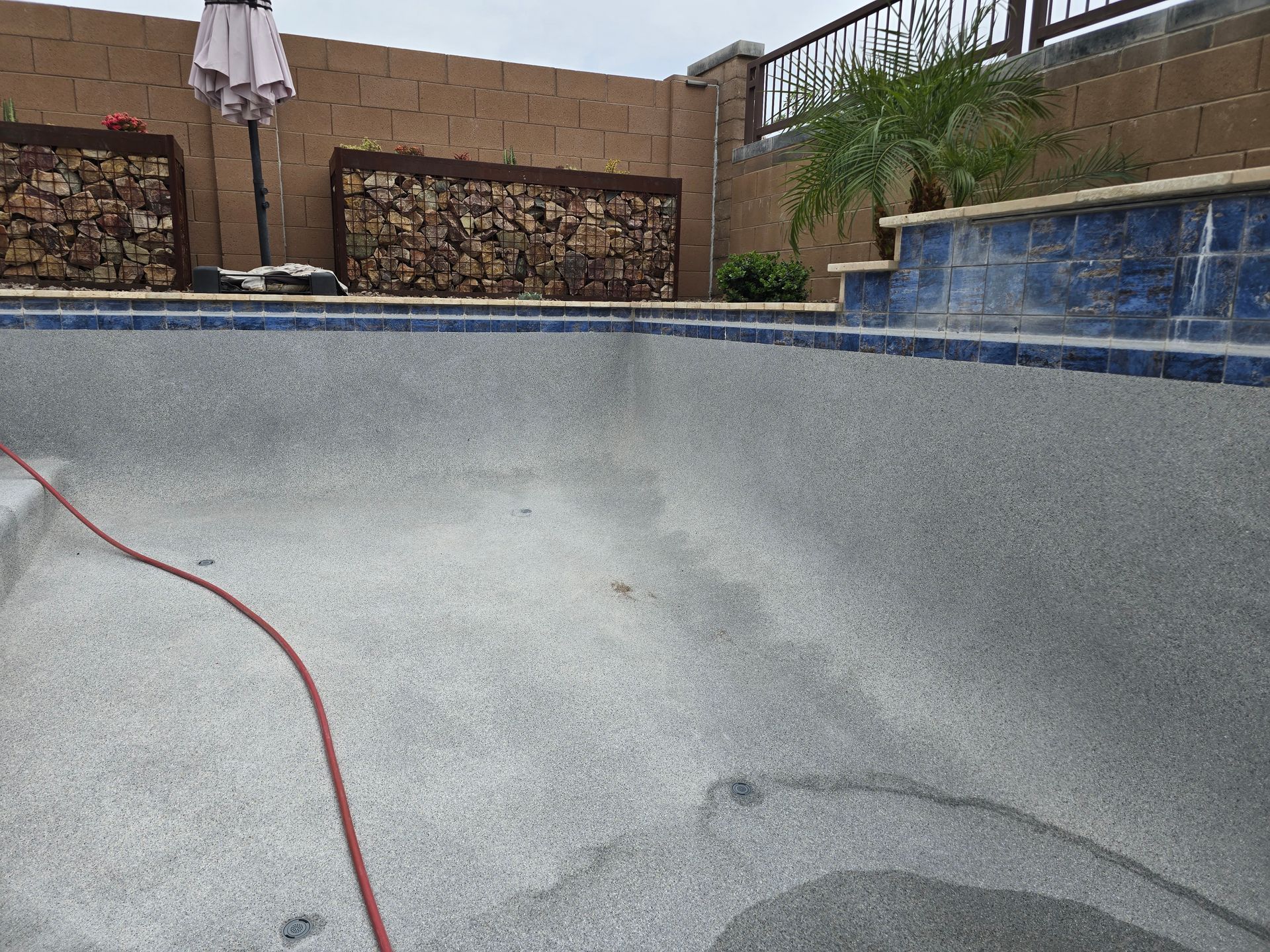 Empty backyard swimming pool with a thick calcium tile line