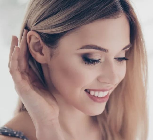 woman brushing hair behind her ears