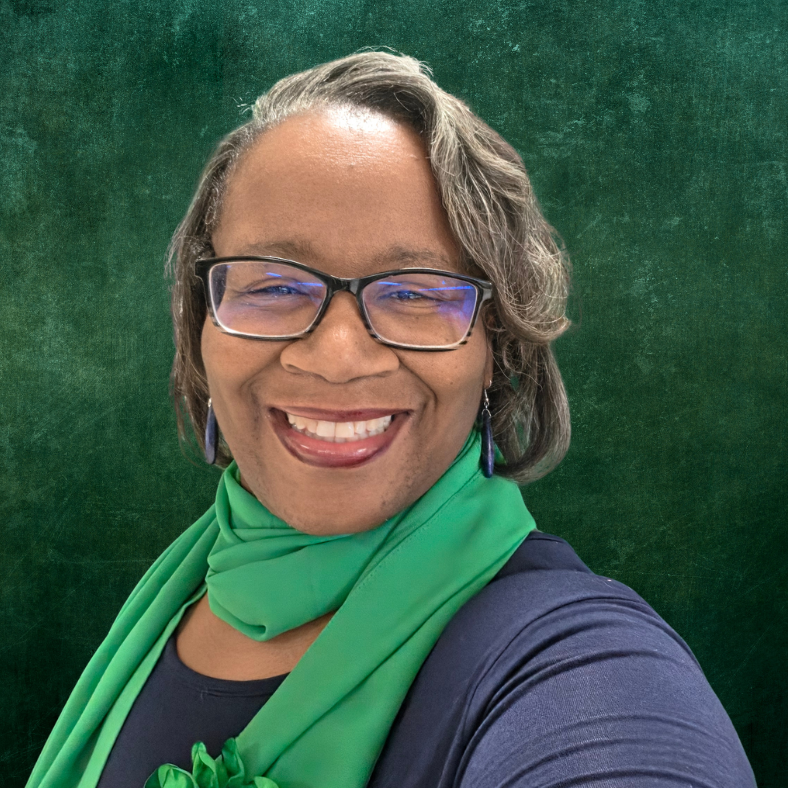 Smiling person in glasses and green scarf against a dark green background