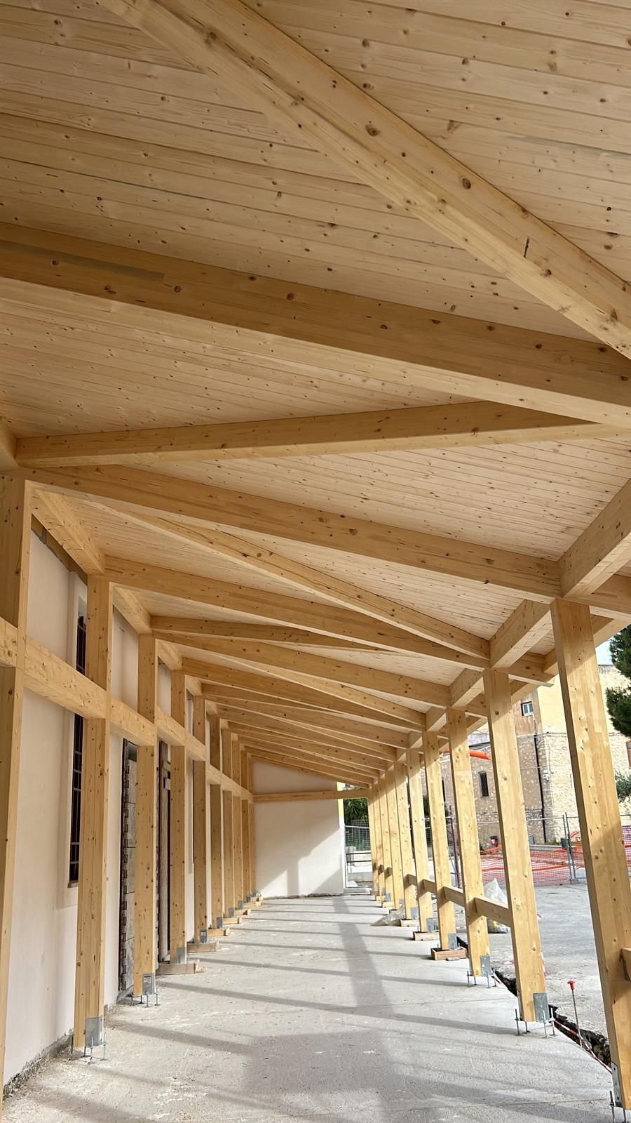 Costruzione in legno, probabilmente un passaggio coperto, con travi e pannelli.