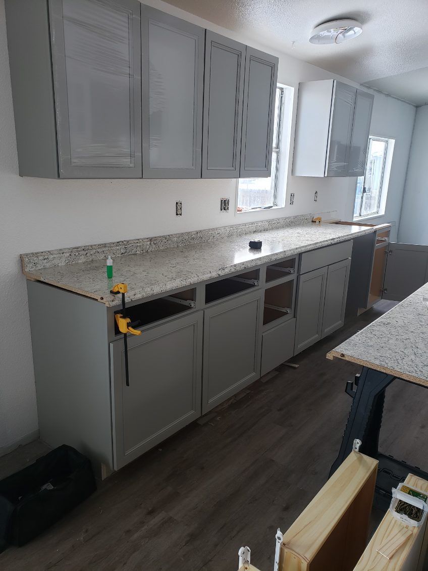 Kitchen with white cabinets, granite counters, and a sink along a long galley layout.