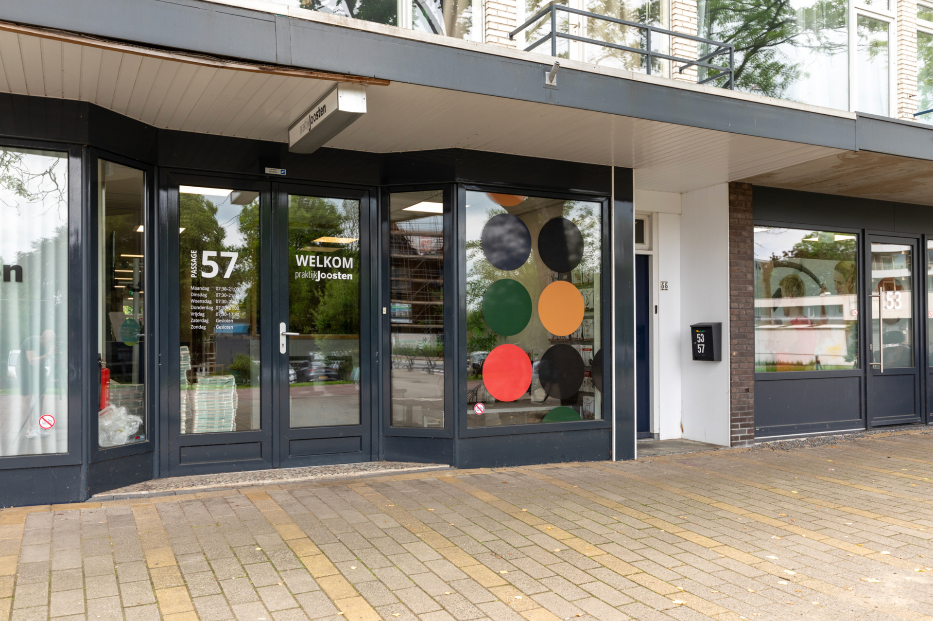 Winkelpui met glazen deuren en kleurrijke ronde decoraties.