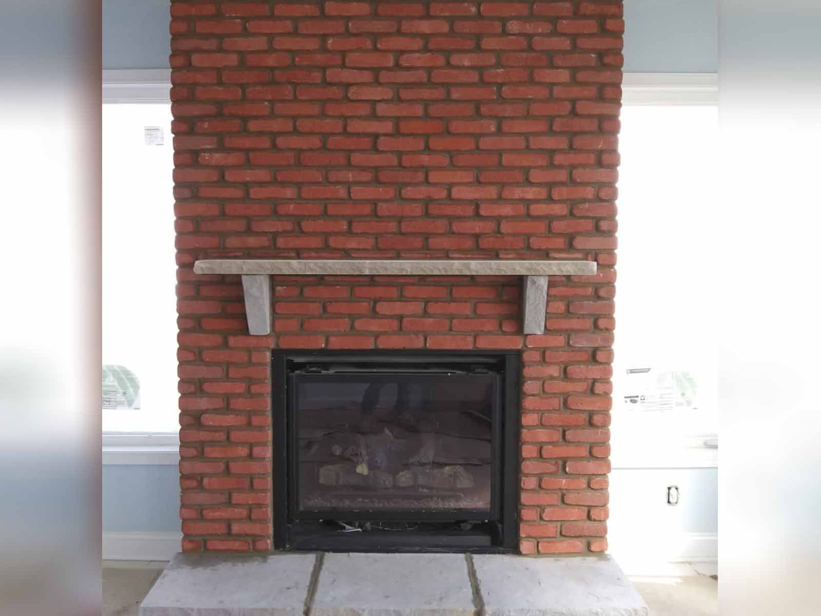 a red brick fireplace with a mantle in a living room .