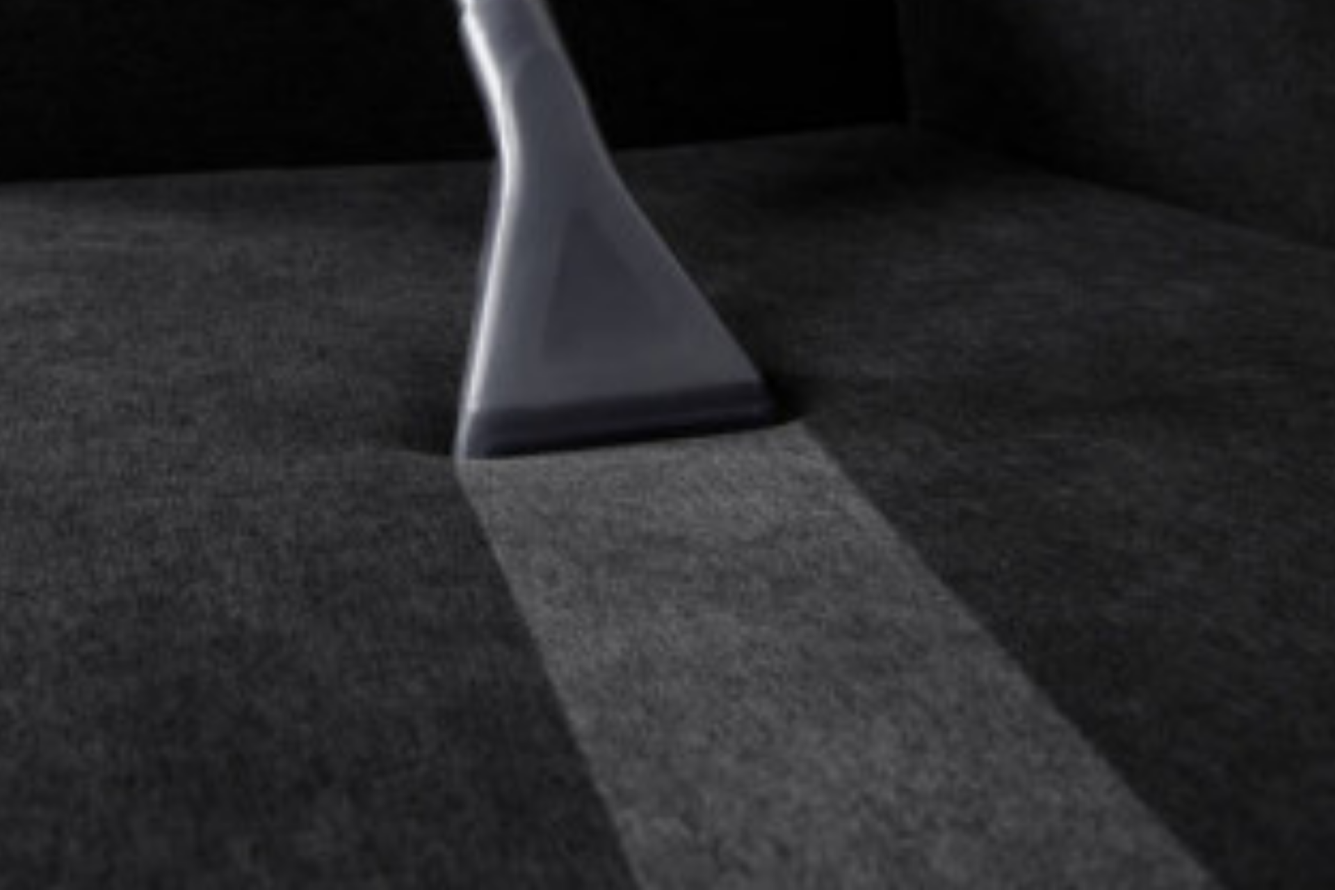 A gray triangular object casting a long shadow on a dark surface