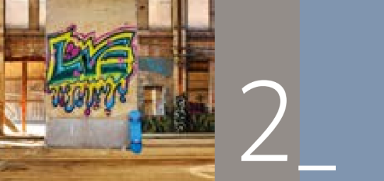 Graffiti an einer Wand, daneben eine Person in einer blauen Jacke; große graue Tafel mit der Zahl 2