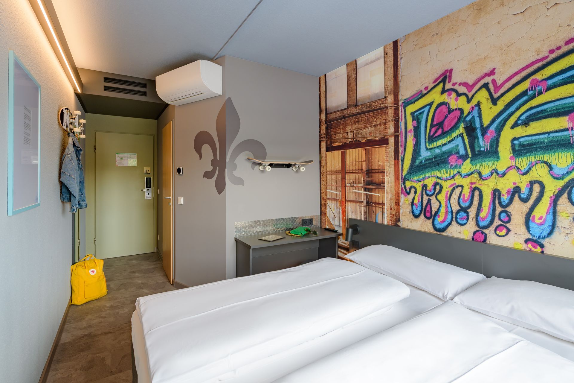 Stilvolles Hotelzimmer mit Graffiti-/ Streetart-Wandkunst und einem kleinen Arbeitstisch. Hotel in Darmstadt.