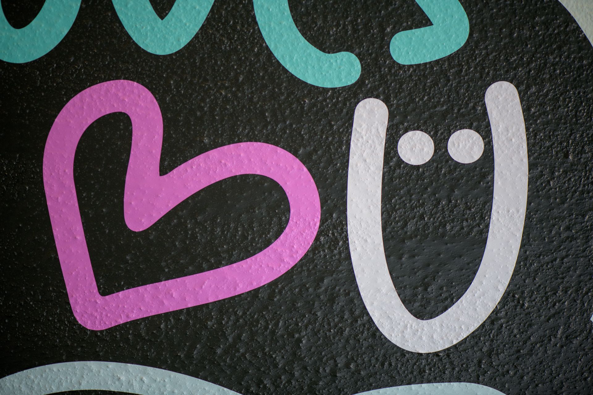 Rosa Herz- und weiße Smiley-Gesichter auf dunklem Tafelhintergrund