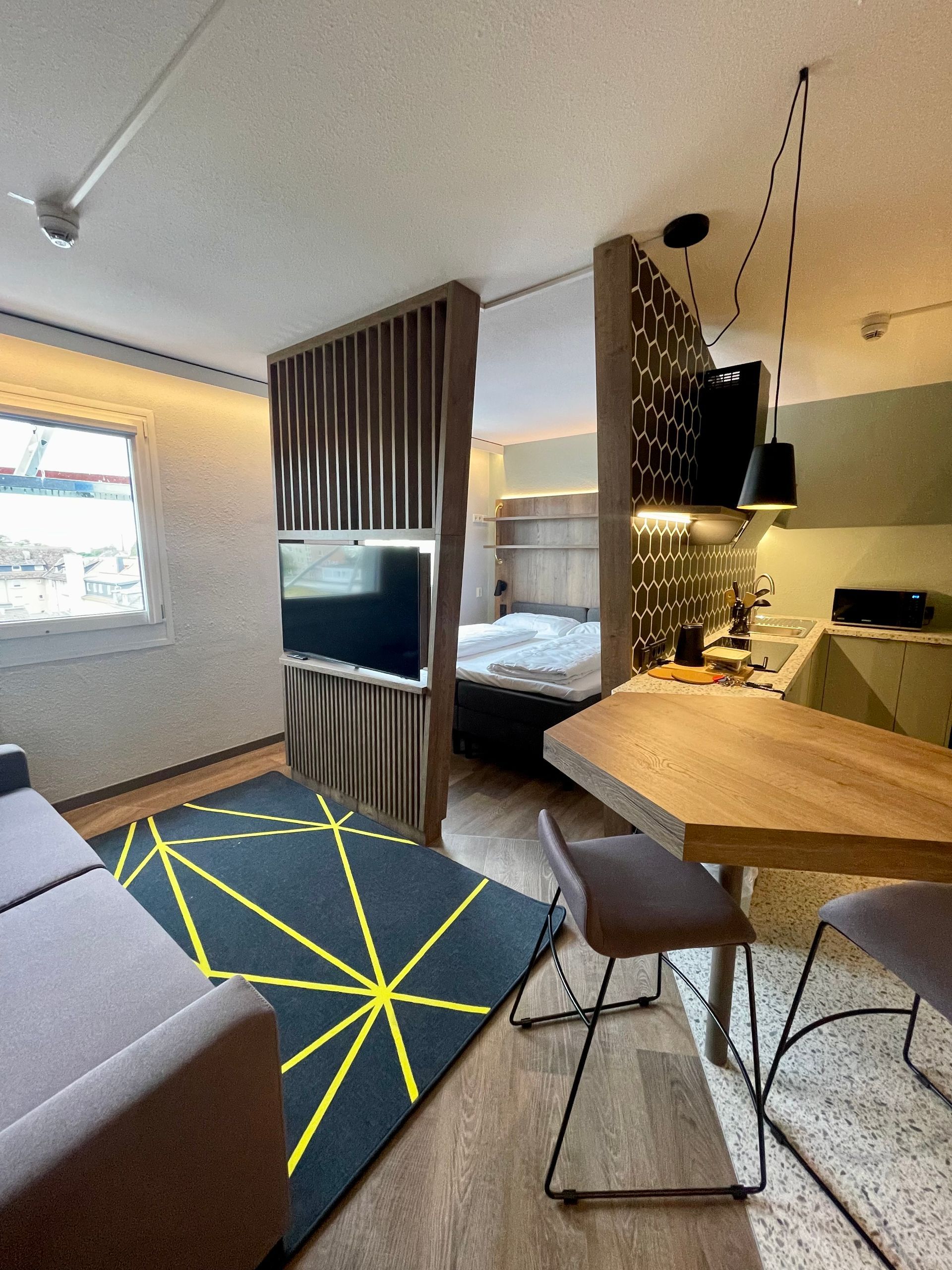 Modernes Studio-Apartment in der Nähe der TU mit Schlafnische, Sofa und Esstisch in einem hellen, offenen Wohnbereich