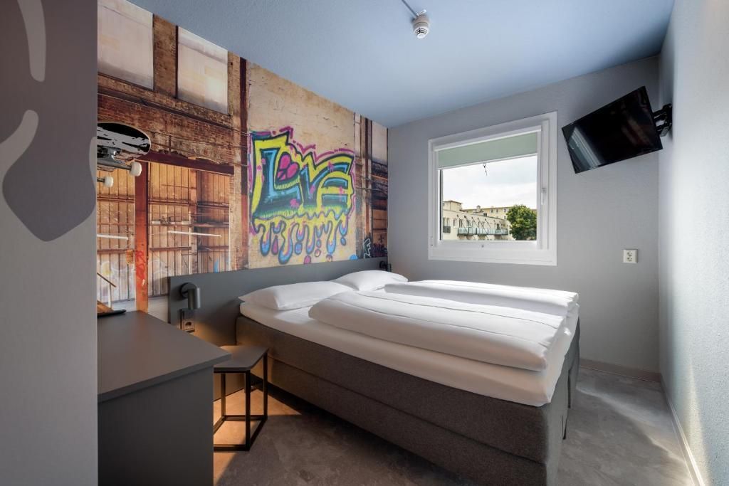 Modernes Schlafzimmer mit Graffiti-Wandbild, Bett, Schreibtisch, im Herzen von Darmstadt.